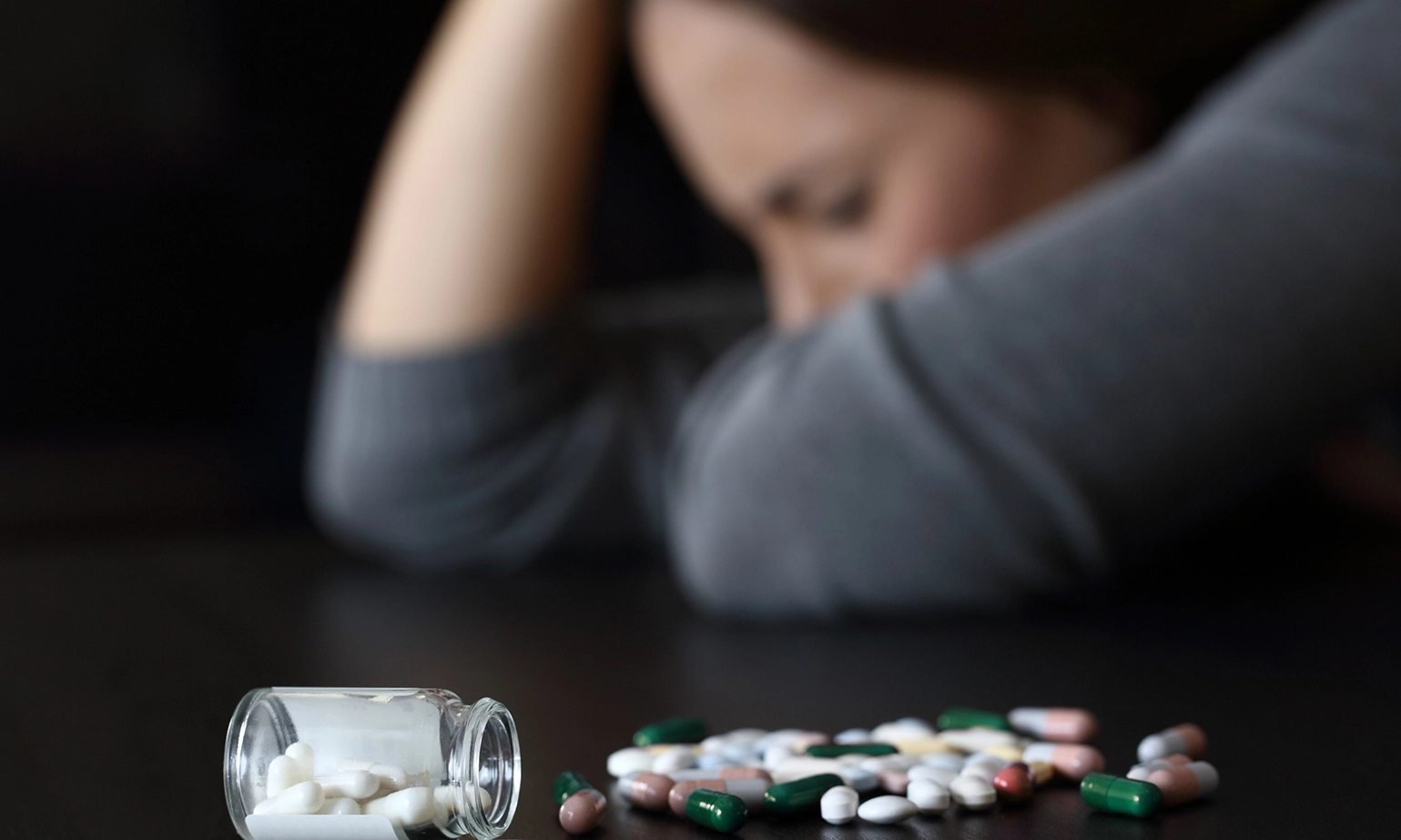 depressed-woman-beside-a-lot-of-pills.webp